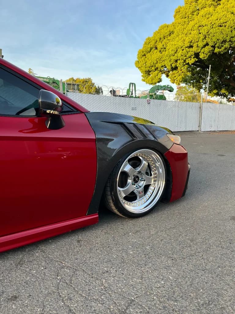 Carbon front fender and wheel of a red Toyota Camry after detailing