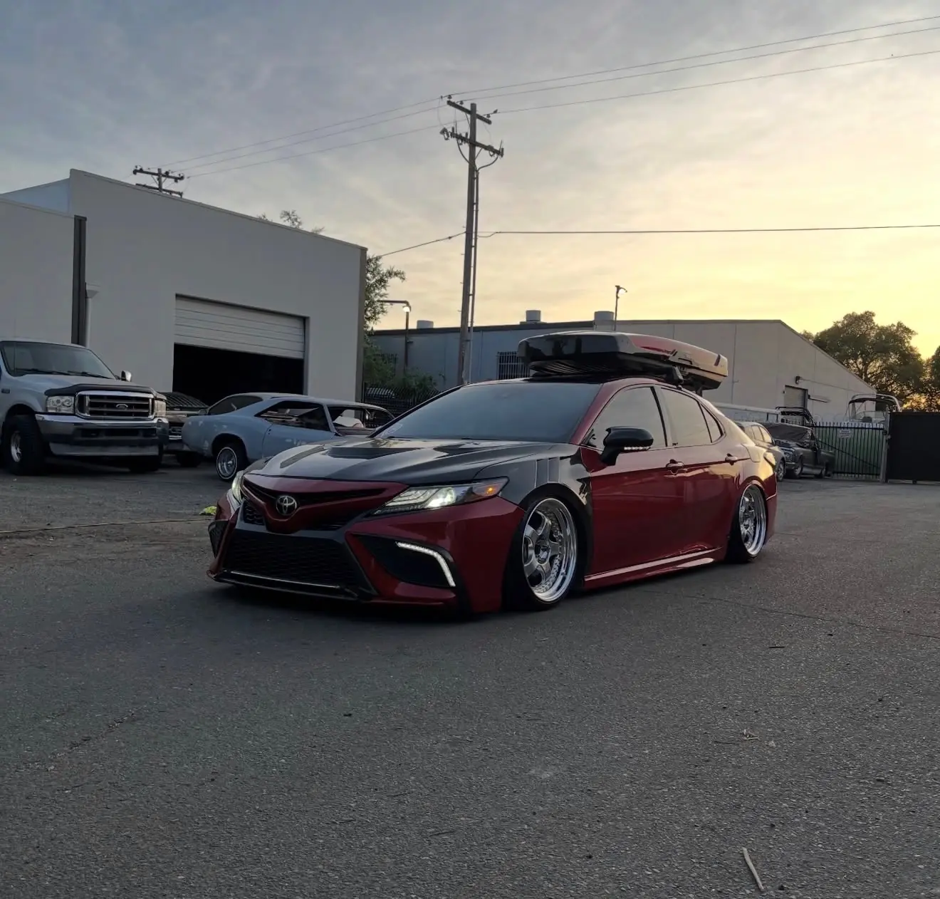 Red slammed Toyota Camry photographed at sunset after detailing