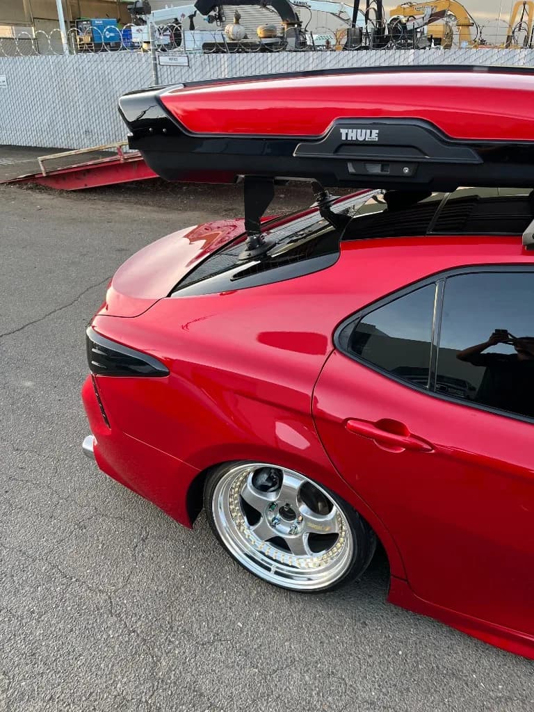 C-pillar, rear wheel and Thule roof box on a red Camry after detailing