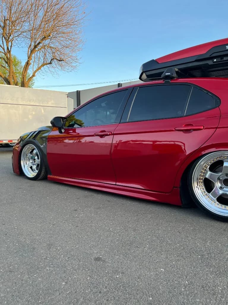 Side profile of a red slammed Toyota Camry after detailing