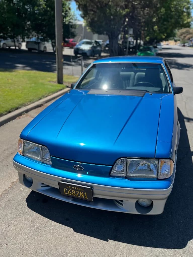 Front view of a blue Fox-body Mustang 5.0 after detailing