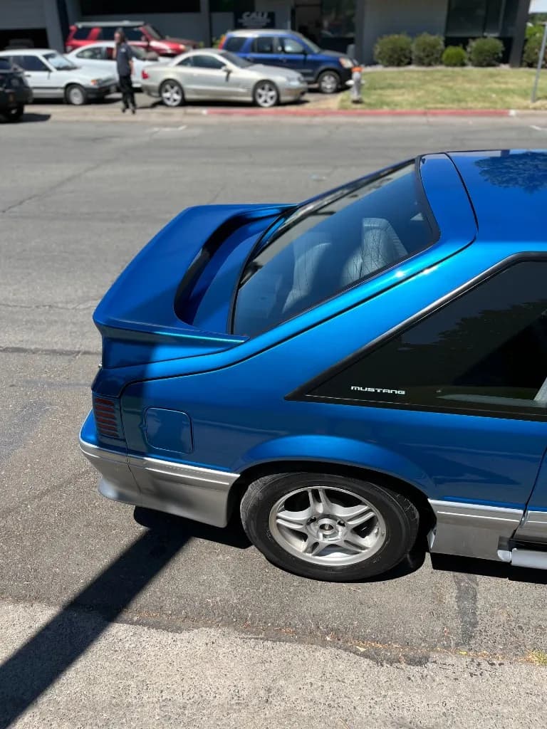Rear quarter of a blue Fox-body Mustang 5.0 after detailing