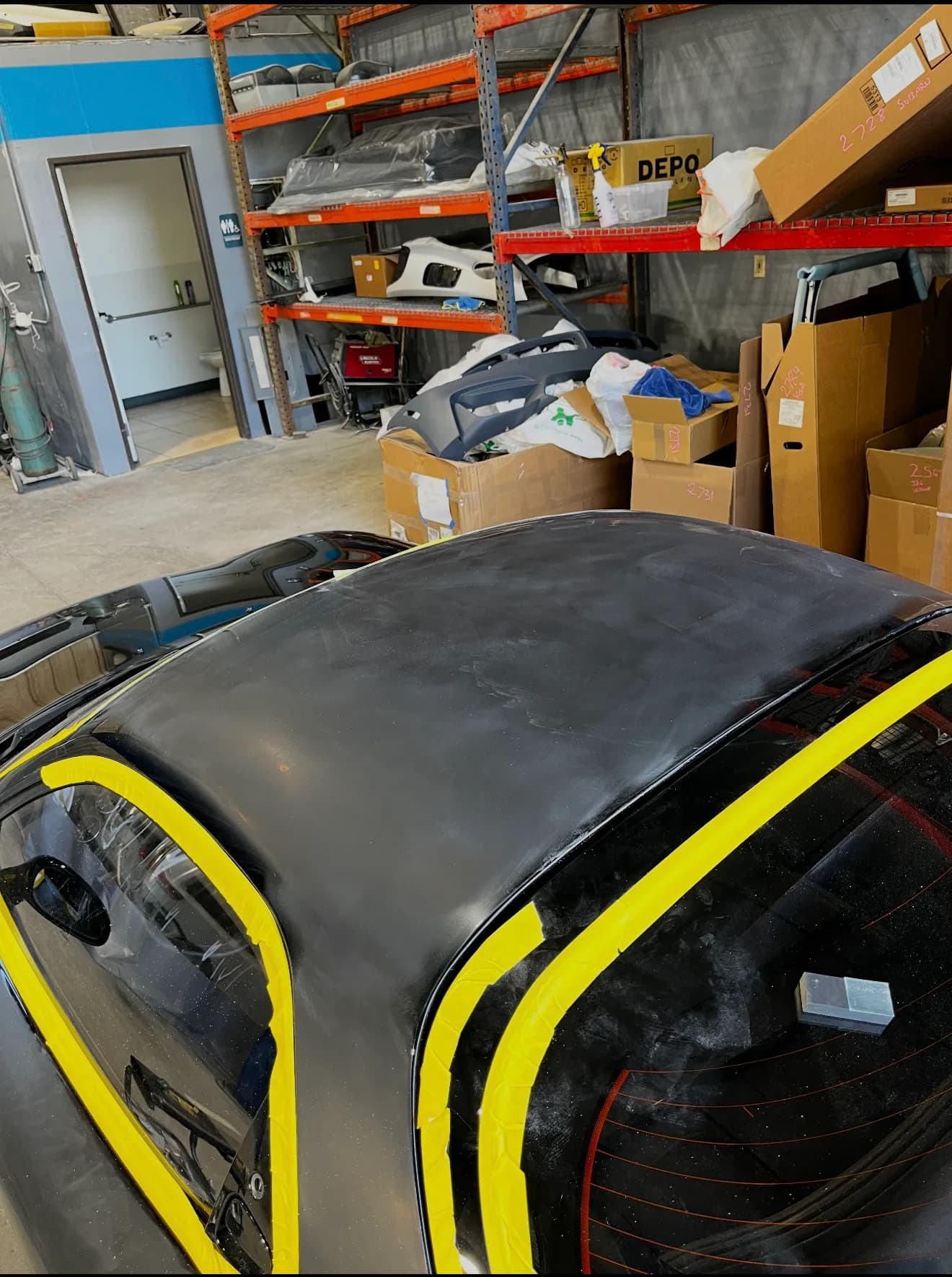 Black vehicle roof taped and prepped during paint correction
