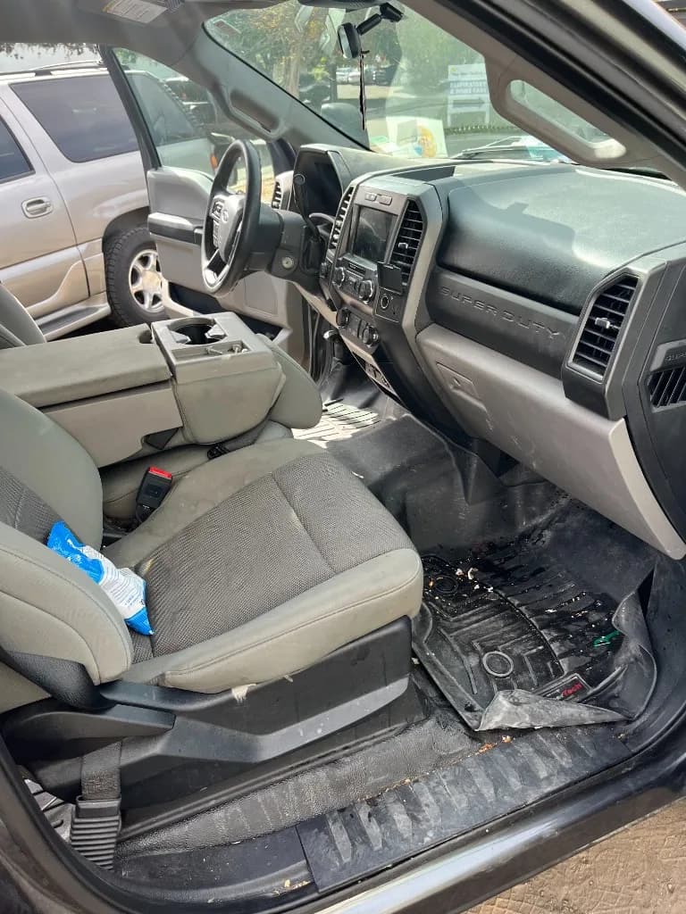 Driver seat and floor of a crew-cab work truck as received, before interior detailing