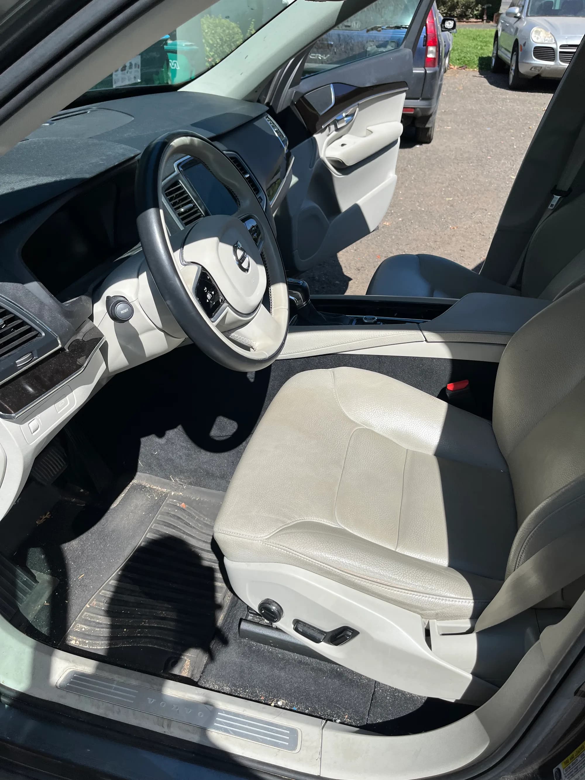 Front seats and dashboard of a beige Volvo during interior work