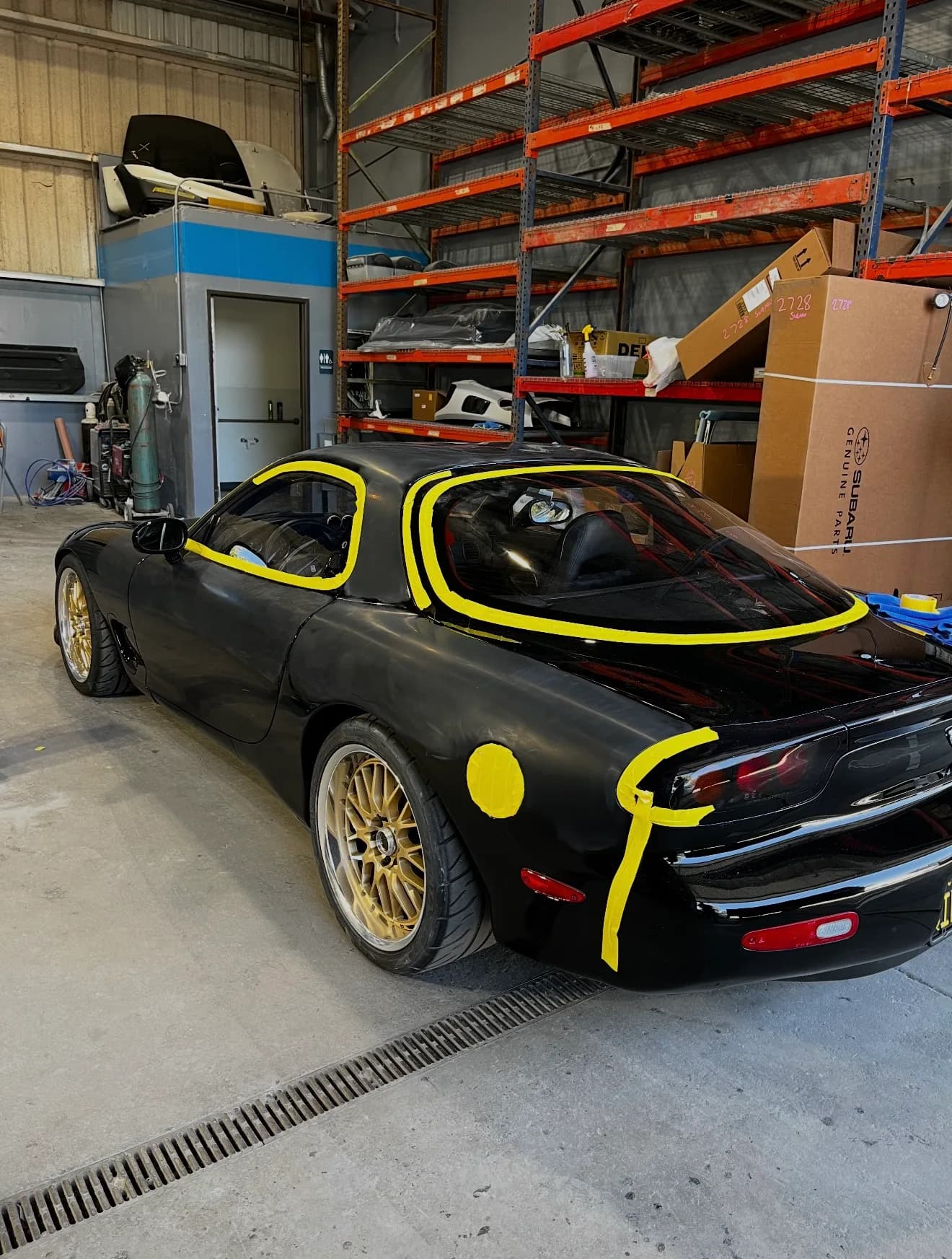 Black coupe masked with tape before paint work
